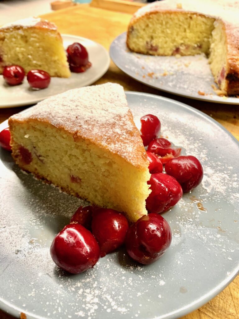 Italian cake being served with cherries